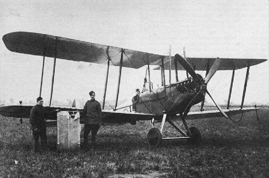 Leefe Robinson seated in the BE2c bi-plane that shot down the German Schütte-Lanz SL 11, with two ground crew, repairing a damaged section of wing, that Leefe inadvertently shot at himself.